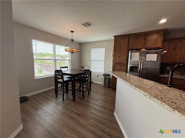 kitchen featuring baseboards, visible vents, and stainless steel fridge with ice dispenser