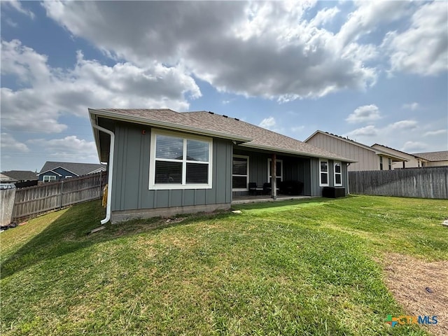 back of house with a lawn, a fenced backyard, and central AC unit