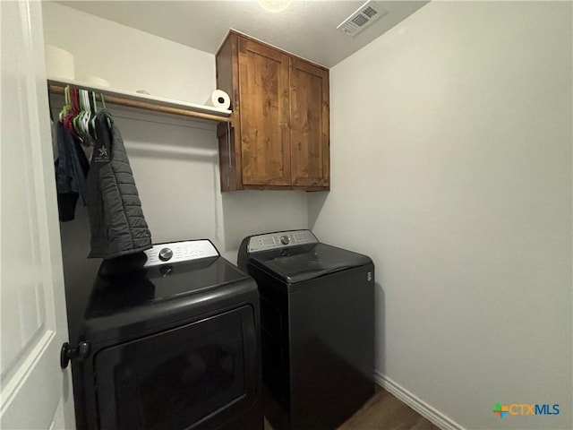 laundry room with baseboards, visible vents, cabinet space, and washer and dryer