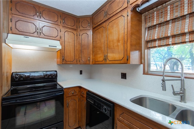 kitchen with sink, light tile patterned floors, black appliances, and a textured ceiling