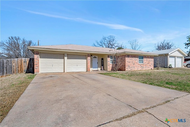 ranch-style home with brick siding, a front yard, fence, a garage, and driveway