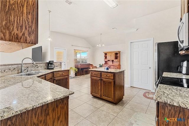 kitchen with light stone countertops, sink, light tile patterned floors, and pendant lighting