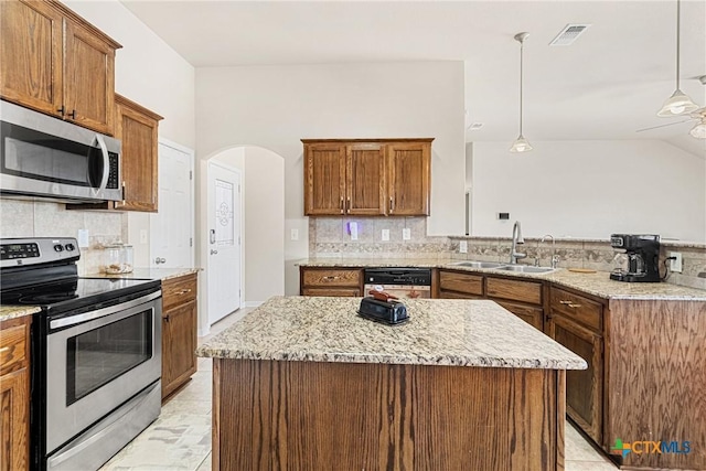 kitchen featuring a kitchen island, hanging light fixtures, appliances with stainless steel finishes, and tasteful backsplash