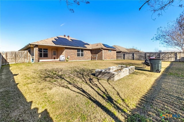 back of house with a yard and solar panels