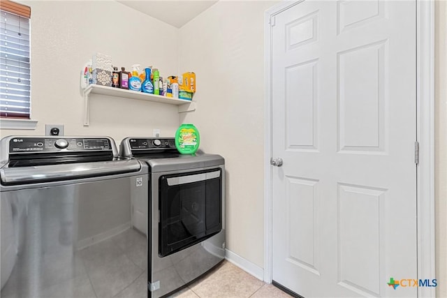 laundry room featuring independent washer and dryer and light tile patterned flooring