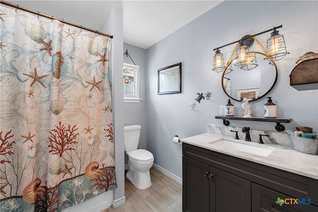 bathroom featuring toilet, an inviting chandelier, vanity, and hardwood / wood-style floors