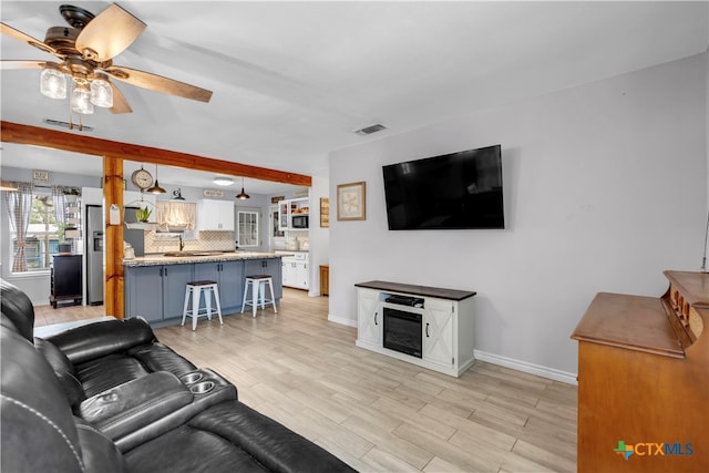 living room featuring ceiling fan and light hardwood / wood-style floors