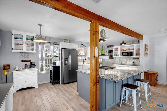 kitchen featuring light hardwood / wood-style floors, white cabinetry, light stone counters, stainless steel refrigerator with ice dispenser, and hanging light fixtures