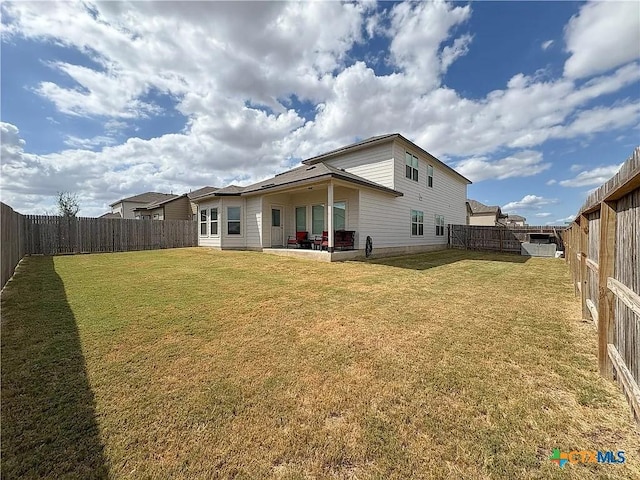 rear view of property featuring a patio and a lawn