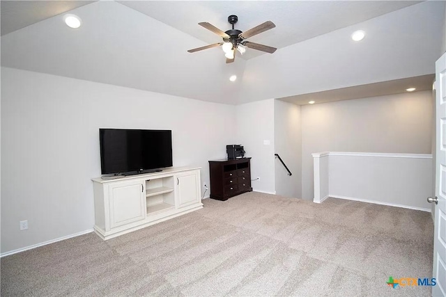 unfurnished living room with vaulted ceiling, light colored carpet, and ceiling fan