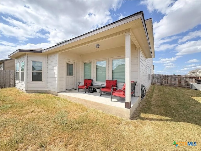 rear view of house featuring central AC, a lawn, and a patio area