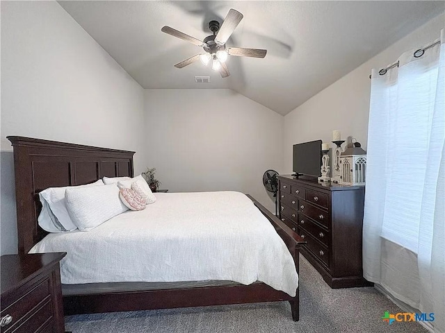 bedroom with vaulted ceiling, ceiling fan, and carpet flooring