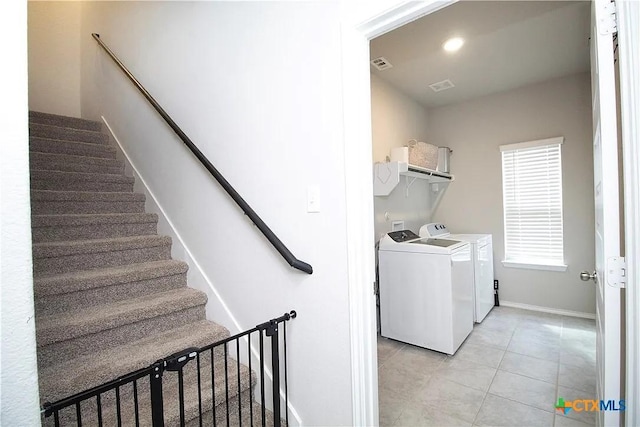 washroom featuring washing machine and dryer and light tile patterned flooring