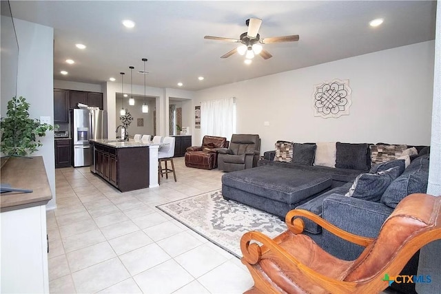 tiled living room featuring ceiling fan and sink