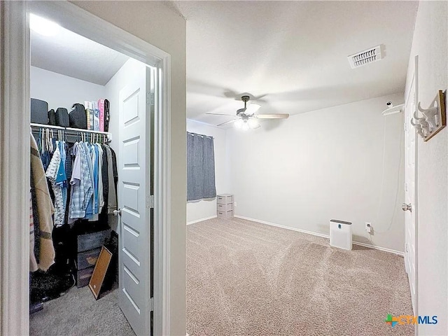 spacious closet featuring ceiling fan and carpet