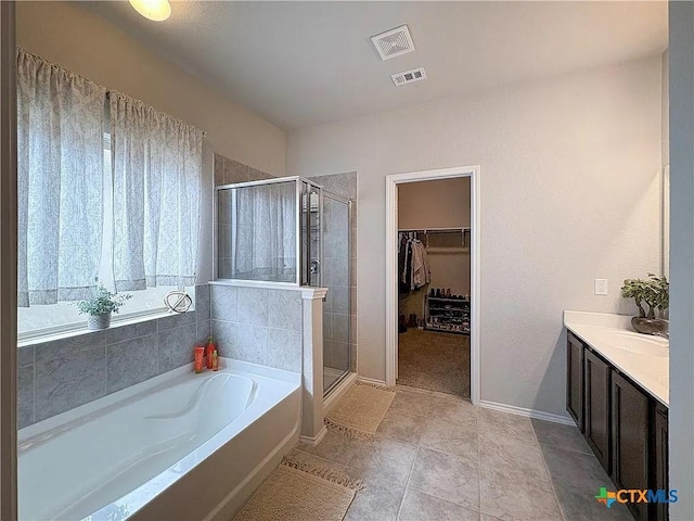 bathroom with tile patterned floors, vanity, and shower with separate bathtub