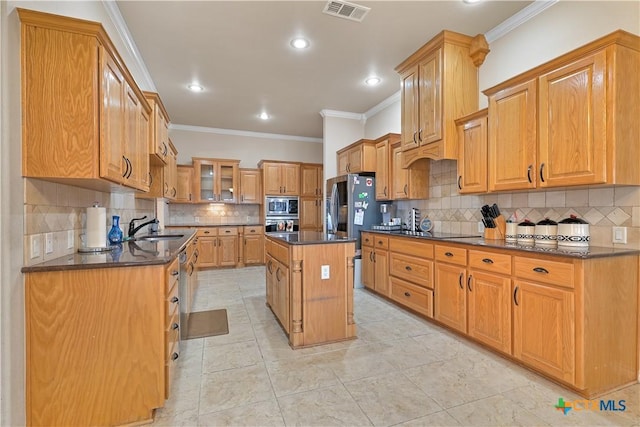 kitchen with backsplash, sink, stainless steel appliances, and a kitchen island