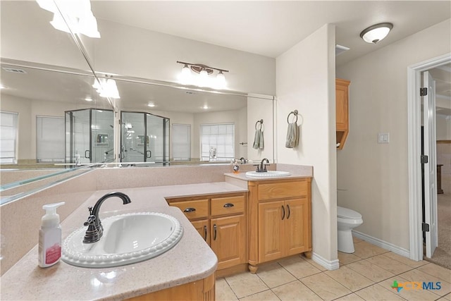 bathroom with tile patterned floors, walk in shower, toilet, and vanity