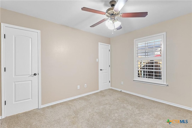 unfurnished room featuring ceiling fan and light carpet