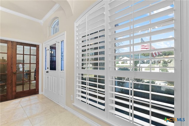 tiled foyer entrance featuring french doors, a wealth of natural light, and ornamental molding