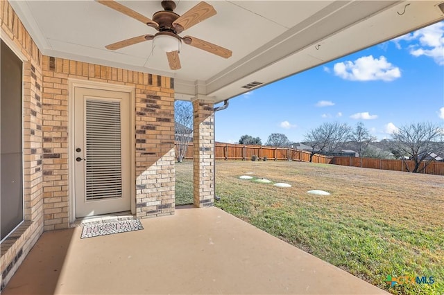 exterior space with ceiling fan, a yard, and a patio