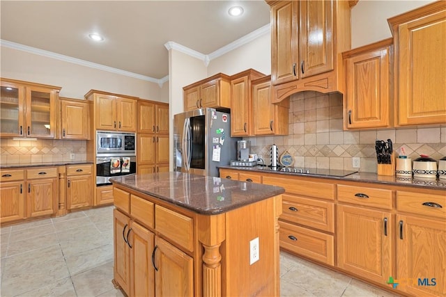 kitchen with appliances with stainless steel finishes, a center island, dark stone countertops, backsplash, and ornamental molding