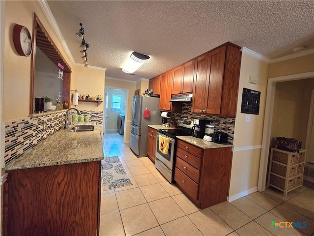kitchen with under cabinet range hood, stainless steel appliances, a sink, and tasteful backsplash