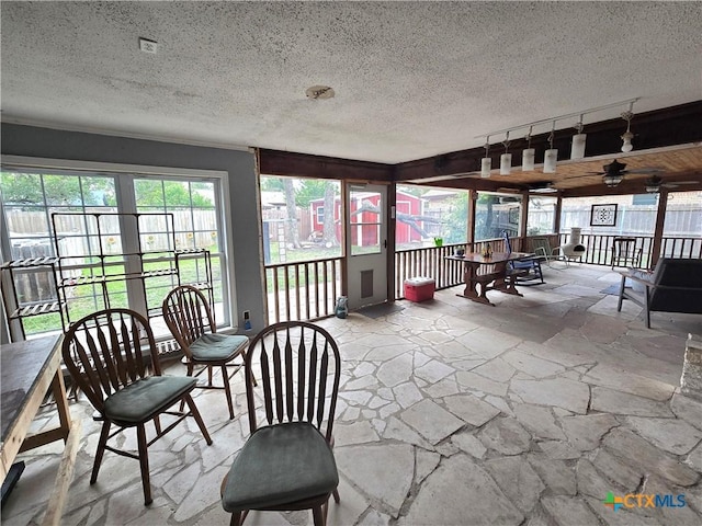 sunroom featuring stone flooring and a textured ceiling