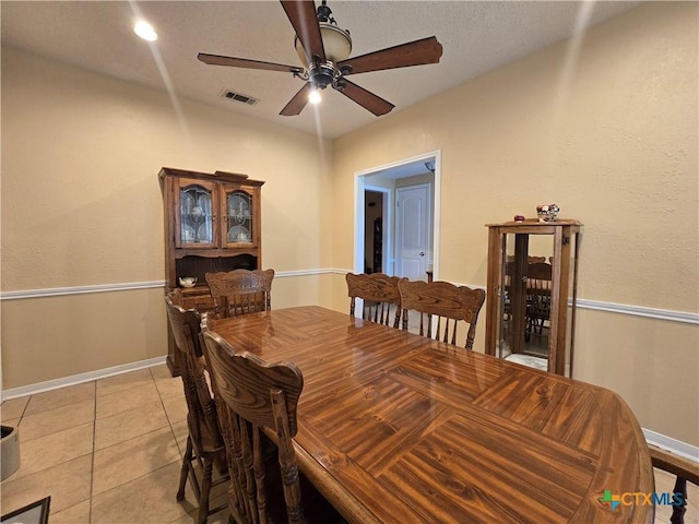 dining space with light tile patterned flooring, ceiling fan, visible vents, and baseboards