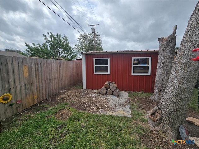 view of outdoor structure with a fenced backyard and an outbuilding