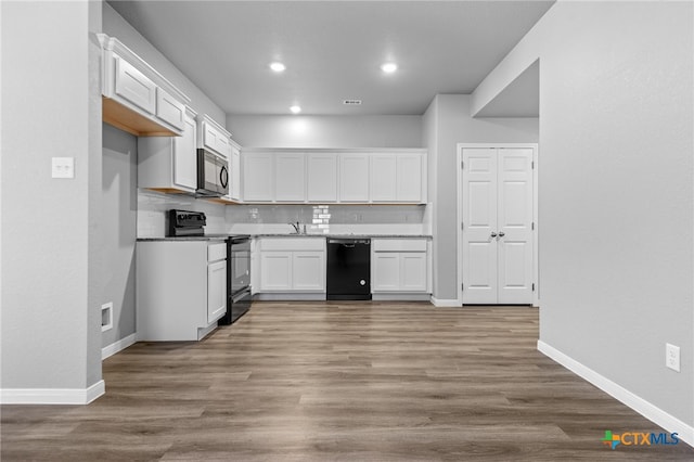 kitchen featuring black appliances, white cabinetry, backsplash, sink, and light hardwood / wood-style floors