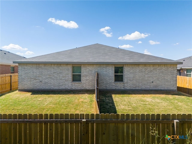 rear view of property featuring a lawn