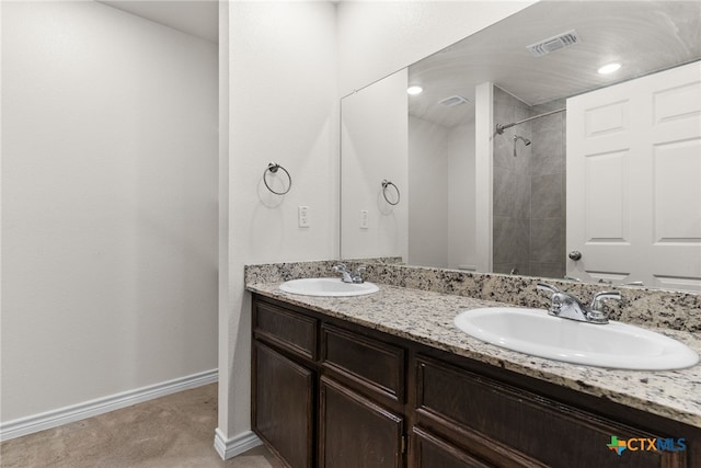 bathroom with tiled shower and vanity