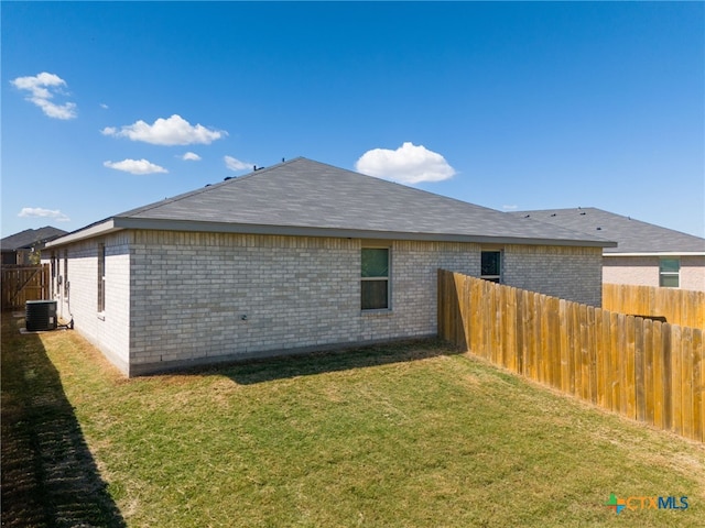 exterior space featuring central AC unit and a yard