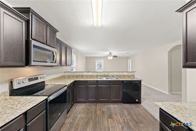 kitchen featuring a textured ceiling, stainless steel appliances, ceiling fan, sink, and dark hardwood / wood-style floors