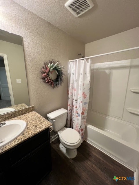 full bathroom featuring vanity, shower / bath combination with curtain, toilet, a textured ceiling, and wood-type flooring