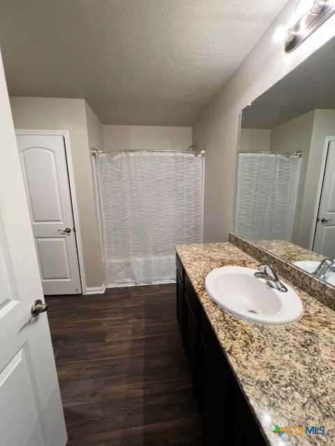 bathroom with a shower with curtain, vanity, a textured ceiling, and hardwood / wood-style flooring