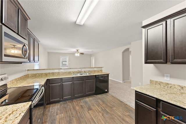 kitchen featuring ceiling fan, sink, stainless steel appliances, dark hardwood / wood-style flooring, and a textured ceiling