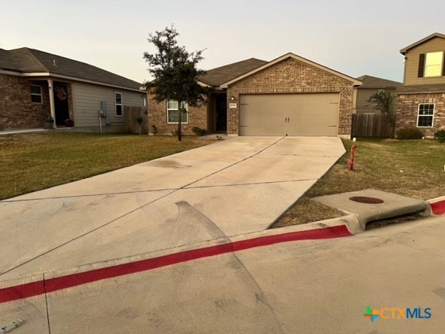 single story home featuring a garage and a front lawn