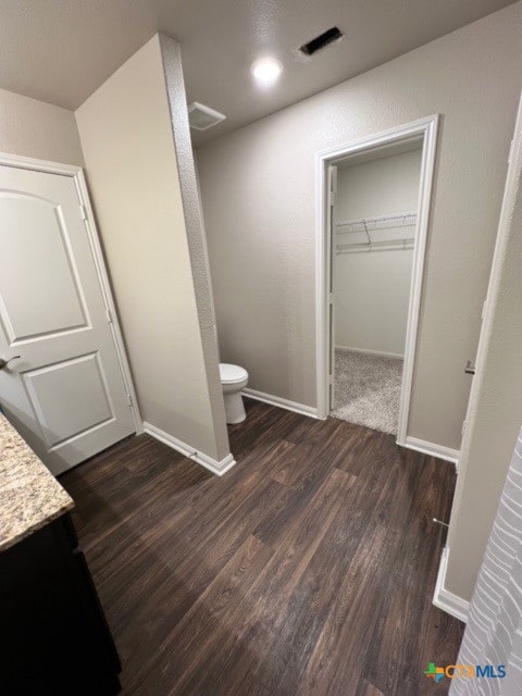 bathroom with vanity, toilet, and wood-type flooring