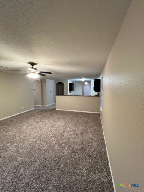 unfurnished living room featuring carpet flooring and ceiling fan