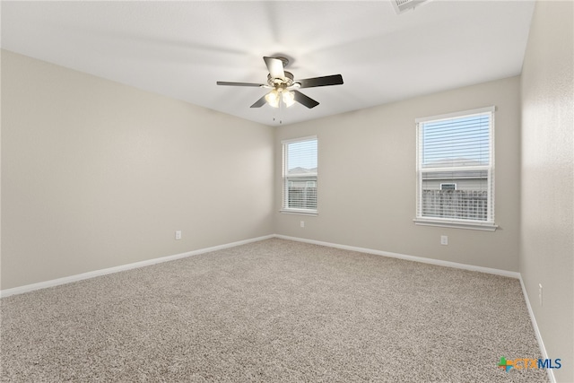 carpeted spare room featuring baseboards and ceiling fan