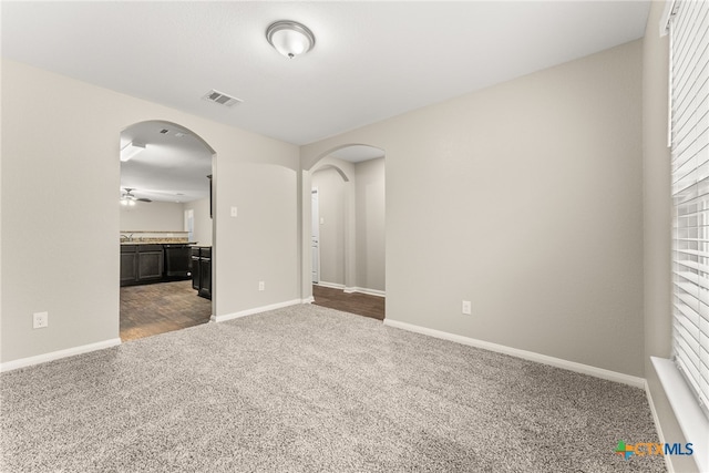 spare room featuring ceiling fan and carpet