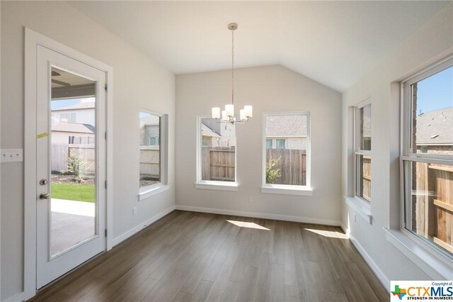 2258 Hoja Ave, New Braunfels, TX 78132 - unfurnished dining area featuring healthy amount of natural light, a chandelier, dark wood-style floors, vaulted ceiling, and baseboards