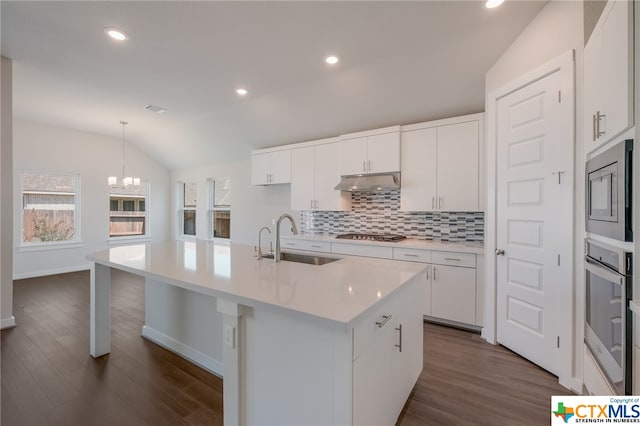 kitchen featuring white cabinetry, lofted ceiling, sink, and an island with sink