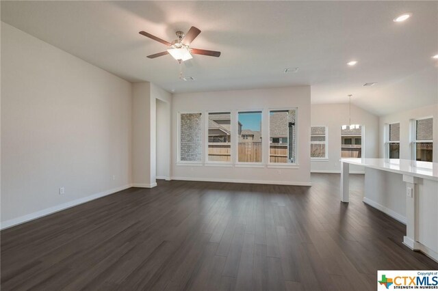 2258 Hoja Ave, New Braunfels, TX 78132 - unfurnished living room with dark wood finished floors, baseboards, ceiling fan, recessed lighting, and a chandelier