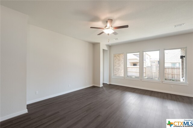 spare room with dark hardwood / wood-style flooring and ceiling fan