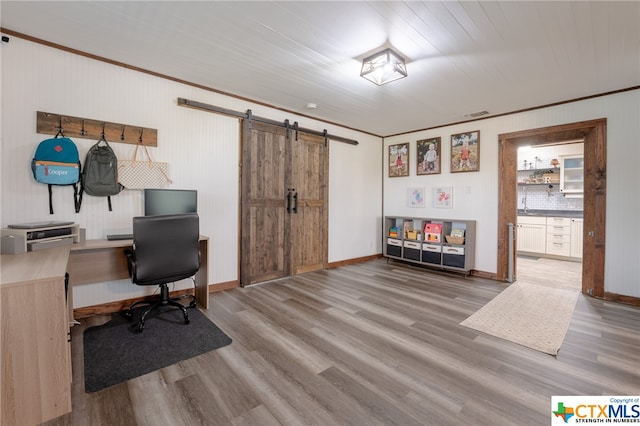 office area featuring a barn door, crown molding, and hardwood / wood-style floors