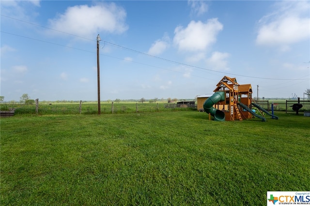 view of playground with a lawn and a rural view