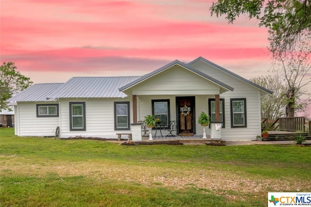 view of front facade with a porch and a yard